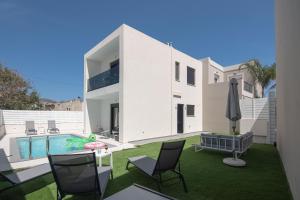a white house with a yard with a swimming pool at Tolis Exclusive Villa in Kissamos