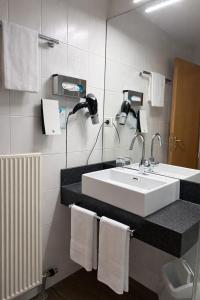a bathroom with a sink and a mirror and towels at Hotel Reinhardts in Bietigheim-Bissingen +31 photos
