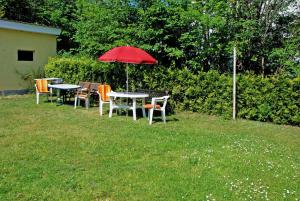 a group of tables and chairs with an umbrella at Villa Waldblick in Baabe in Baabe