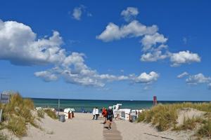 a group of people walking down a sandy beach at Villa Waldblick in Baabe in Baabe