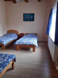 a room with two beds and a window at Napsugár Apartman in Szaknyér