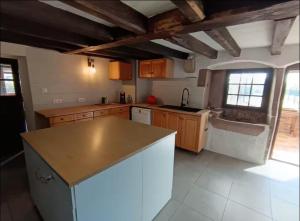 a kitchen with wooden cabinets and a counter top at Gîte MARISA in Champagney