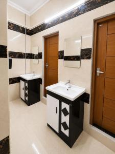 a bathroom with two sinks and a mirror at W H Nest Hostel in Cochin
