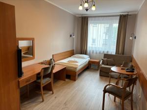 a hotel room with a bed and a table and chairs at Hotel Domino in Głubczyce