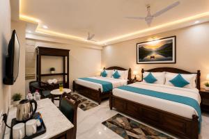a hotel room with two beds and a table at Hotel Sugandh Retreat Near Bus Stand Jaipur in Jaipur