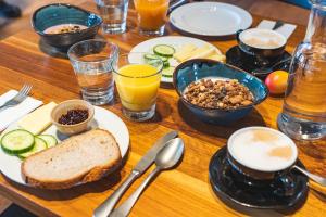 a wooden table topped with plates of food and drinks at Scuol Youth Hostel in Scuol