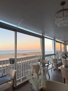 a dining room with a view of the beach at Hôtel de la Plage in Narbonne