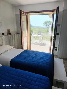 a bedroom with a bed and a sliding glass door at Agriturismo Bordigaie in Bruscoli