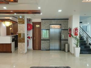 a lobby with a staircase in a building at RR Hotel & Resort by Sonachi in Dharamshala