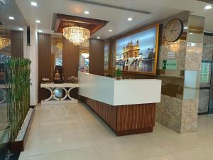 a hotel lobby with a reception counter and a clock at RR Hotel & Resort by Sonachi in Dharamshala