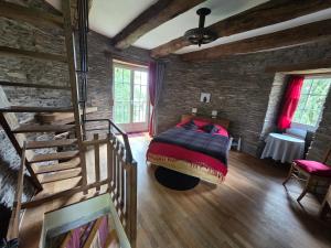 a bedroom with a bed in a brick wall at Le Moulin de Bréhaut in Augan