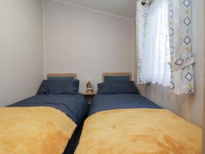 two beds in a small room with a window at Willerby Malton in Ruthin +55 photos