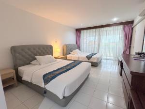 a hotel room with two beds and a window at NJ INTHAI Hotel in Sathani Chiang Rak +18 photos