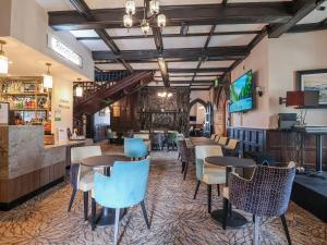 a restaurant with tables and chairs and a bar at Willerby Malton in Ruthin