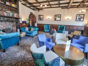 a lobby with blue couches and tables and chairs at Willerby Malton in Ruthin
