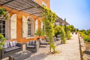 an outdoor patio with couches and a pergola at Domaine de Roque Haute in Portiragnes
