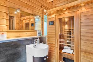 a bathroom with a white sink and a shower at Chalets zum Latschen in Mauth +24 photos