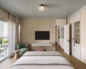 a bedroom with a bed and a tv on the wall at Imperial Island by Louis Hotels in Yeroskipou