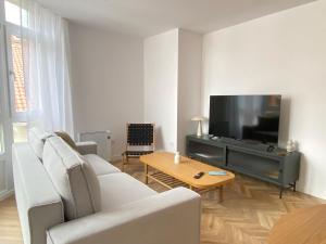 a living room with white furniture and a flat screen tv at Praia - Boa Onda in Cee