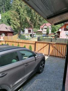 a car parked in a driveway next to a fence at MATT'S House in Tuşnad