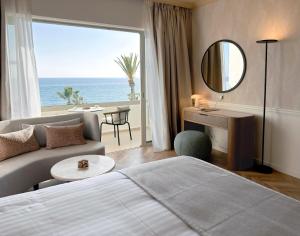 a hotel room with a bed and a view of the ocean at Imperial Island by Louis Hotels in Yeroskipou