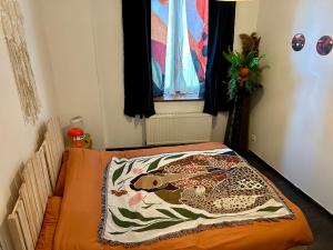 a bedroom with a bed with a blanket on it at Le Néococoon in Neufchâteau