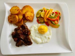 a plate of food with fried eggs and vegetables at Meyrick Bed and Breakfast in Harare +9 photos