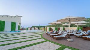 a group of chairs and umbrellas next to a pool at MD Hotel By Gewan in Dubai