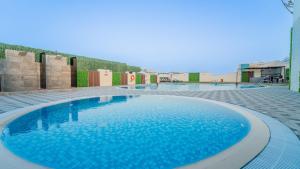 a large blue swimming pool in a building at MD Hotel By Gewan in Dubai