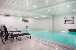 a swimming pool in a room with a table and a chair at Wlat Hotel in Erbil