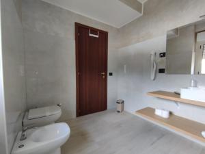 a white bathroom with a toilet and a sink at Residence Hotel Azzurro in LʼAquila +81 photos