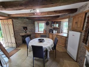 a kitchen with a table with chairs and a refrigerator at Le Moulin de Bréhaut in Augan +35 photos