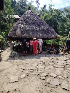 a group of people standing in front of a hut at Ramon's Homestay in Banga-an