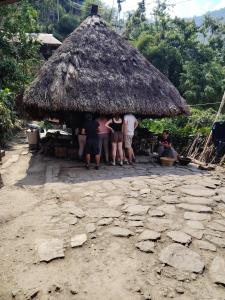 a group of people standing outside of a hut at Ramon's Homestay in Banga-an