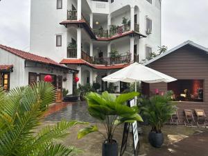 an umbrella in front of a building with plants at Anio Ha Giang Hotel in Ha Giang