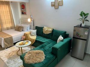 a living room with a green couch and a bed at Yemane luxury Studio in Mombasa