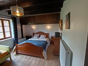 a bedroom with a bed with a blue comforter at Gîte MARISA in Champagney