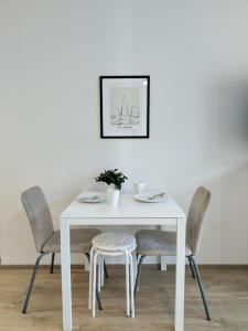 a white dining table and chairs with a white table at Foliate Living Varpu in Jyväskylä