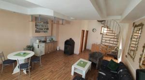 a living room with a table and a kitchen at Apartmani 077 in Drvar