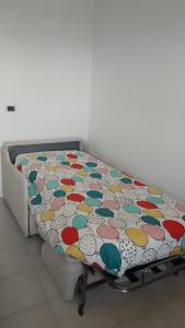 a bed with a colorful comforter on top of it at Bilocale sul Trasimeno in San Feliciano