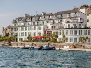 a large white building next to a body of water at 24 The Salcombe in Salcombe