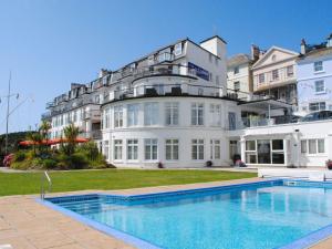 a large white building with a swimming pool in front of it at 24 The Salcombe in Salcombe