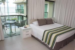 um quarto com uma cama e uma varanda com uma mesa em Namoa Pousada em Cabo de Santo Agostinho