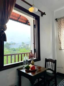 a table with fruit on it in front of a window at Anio Ha Giang Hotel in Ha Giang