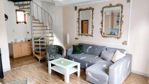 a living room with a couch and a stair case at Apartmani 077 in Drvar
