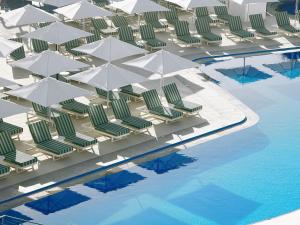 an overhead view of a pool with lawn chairs and umbrellas at Imperial Island by Louis Hotels in Yeroskipou +43 photos