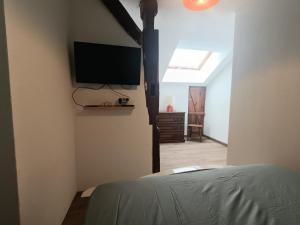 a bedroom with a flat screen tv on the wall at Gîte MARISA in Champagney