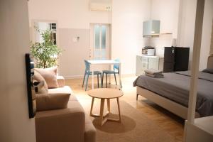 a bedroom with a bed and a table and a kitchen at GIA Hotel & Serviced Apartment in Nhơn Trạch