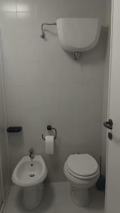 a white bathroom with a toilet and a sink at Bilocale sul Trasimeno in San Feliciano +7 photos