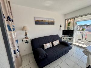 a living room with a couch and a tv at Le Surf in Mimizan-Plage